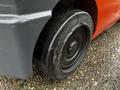 A close-up of a black rubber wheel from a 2017 Toyota 8FCGCU25 forklift showing tread and detailing on the wheel surface