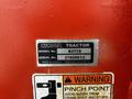 A label on a red Kubota tractor indicating the model B2778 and serial number 21909613 with a warning about pinch points