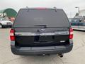 A black 2017 Ford Expedition showing the rear with a chrome strip featuring the word Expedition on the tailgate and a visible exhaust pipe