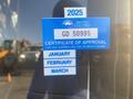 A blue sticker on a vehicle window indicating the certificate of approval for British Columbia with the text for January February March and the year 2025