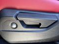 Close-up of the door handle and adjustment switch in a 2023 Acura MDX featuring black and red accents