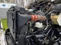A close-up view of the engine compartment of a 2014 Kenworth T370 showing the radiator hoses, engine components, and surrounding mechanical parts
