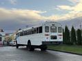 White 2015 International 3000 school bus viewed from the rear with large windows and distinct red and yellow lights