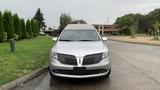 A silver 2013 Lincoln MKT parked with a prominent front grille and sleek body design