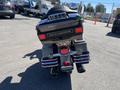 A 2004 Harley-Davidson Flhtcui motorcycle viewed from the rear showcasing its distinctive tail light and chrome exhaust pipes