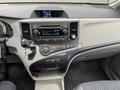 Interior dashboard of a 2013 Toyota Sienna featuring a console with digital display buttons and controls for audio and climate settings