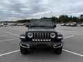 A black 2019 Jeep Wrangler facing forward with round headlights a seven-slot grille and prominent front bumper