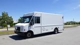 A white 2006 Ford Econoline cargo van with front windows and a large boxy body designed for commercial use