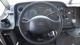 The interior of a 2011 Ford Econoline showing the steering wheel dashboard and control panel with gauges and buttons