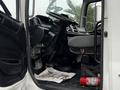 Interior of a 2020 Hino 338 truck showing the driver's seat steering wheel pedals and a fire extinguisher on the floor