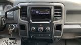 The interior dashboard of a 2013 RAM 2500 featuring the radio display air conditioning controls and a gear shift lever