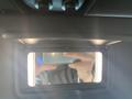 A 2020 Jeep Wrangler interior mirror with illuminated edges reflecting a hand holding a smartphone