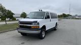 A 2017 Chevrolet Express Quigley 4x4 van in white with a black front grille and orange accents parked on a paved surface