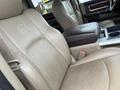 The interior of a 2010 Dodge Ram featuring beige leather seats with a stitched logo on the headrest and a center console with a dark, textured finish