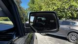 A side mirror of a 2018 Chevrolet Tahoe showing a clear reflection with the warning text about objects being closer than they appear