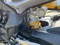 Close-up of the suspension system on a 2018 Triumph Street Triple RS showcasing the shock absorber and linkage with prominent yellow spring