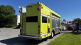 A bright yellow 1995 Freightliner FLL086 fire truck with a silver ladder on the side and large windows