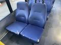 Two blue bus seats showing visible wear and tear with some frayed edges