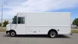 A white 2011 Ford Econoline delivery van with a boxy shape and large side door