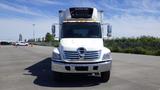 A white 2009 Hino 268 box truck with a large cooling unit on top and a prominent logo on the front grille