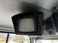 A small black monitor with buttons for power, camera, contrast, bright, and volume mounted on a dashboard