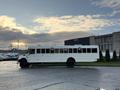 A 2015 International 3000 school bus with a white exterior parked on a lot, featuring large windows and a flat front design