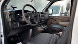 Interior view of a 2005 Chevrolet Express showing the steering wheel dashboard and front seats with seat covers