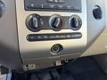 Dashboard controls of a 2013 Ford Expedition featuring dials for climate control and an audio system with various buttons and a central display