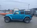 A blue 2020 Jeep Wrangler parked with a black spare tire on the back and sporty wheels