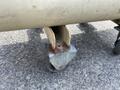 A rusted metal caster wheel attached to a support bracket of a 2000 Wilkerson Refrigerated Air Dryer and Ingersoll-Rand Air Compressor