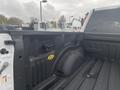 Interior view of the bed of a 2017 Ford F-150 showing the spray-in bed liner and integrated tie-down hooks