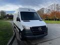 A white 2022 Mercedes-Benz Sprinter van is parked with a sleek design featuring a prominent front grille and large windows