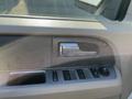 Interior door panel of a 2013 Ford Expedition featuring window controls and a silver handle