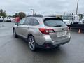 2019 Subaru Outback in silver with a black roof and rear spoiler parked with the back facing the viewer