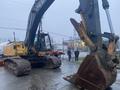 A 2014 John Deere 350G excavator with a large bucket attachment positioned at an angle