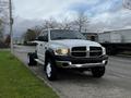 A 2008 Dodge Ram 5500 with a white exterior and black grill is parked on the street with no rear bed and features large wheels and an elevated cab design