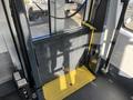 A 2018 Chevrolet Express wheelchair lift with a yellow platform and black metal frame in the foreground