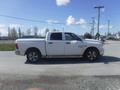 A white 2019 RAM 1500 Classic Eco Diesel pickup truck with a crew cab parked on a gravel road facing left