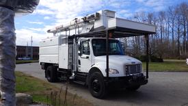 A white 2011 Freightliner M2 Medium Duty truck equipped with an elevated work platform and a utility body