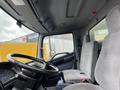 Interior view of a 2008 Hino Conventional Cab showing the steering wheel and two gray fabric seats with seatbelts