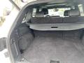 Interior of a 2018 Jeep Grand Cherokee showing a spacious cargo area with a flat floor and black carpeting