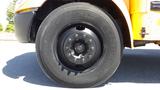 Close-up of a black tire mounted on a 2014 International 3000 bus with visible tread and rim details