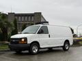 A white 2009 Chevrolet Express van positioned at an angle with a black grille and chrome wheels