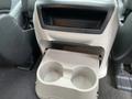 A grey cup holder designed to fit two cups located in the center console of a 2013 Toyota Sienna