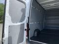 A 2017 Mercedes-Benz Sprinter van with an open rear door revealing a spacious cargo area and gray interior walls