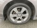 A close-up of the wheel of a 2013 Toyota Sienna showing a silver alloy rim and a black tire with visible treads