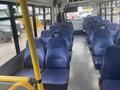 Interior view of a 2017 Chevrolet Express bus with blue fabric-covered seats arranged in rows and a yellow pole for support