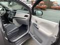 A 2013 Toyota Sienna with a gray interior features a driver's seat, dashboard controls, and door panel visible from an open door