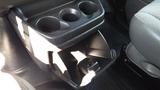 A black cup holder with three circular compartments located in the front interior of a 2015 GMC Savana