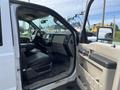 A 2010 Ford F-550 with the driver’s side door open showing the black leather interior and dashboard